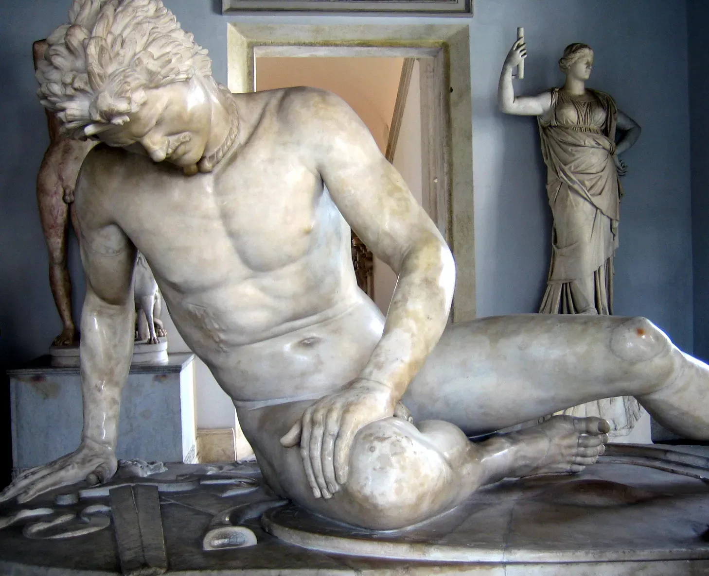 el gálata moribundo: estatua de mármol de un guerrero herido que se sostiene sobre un brazo en la sala de un museo