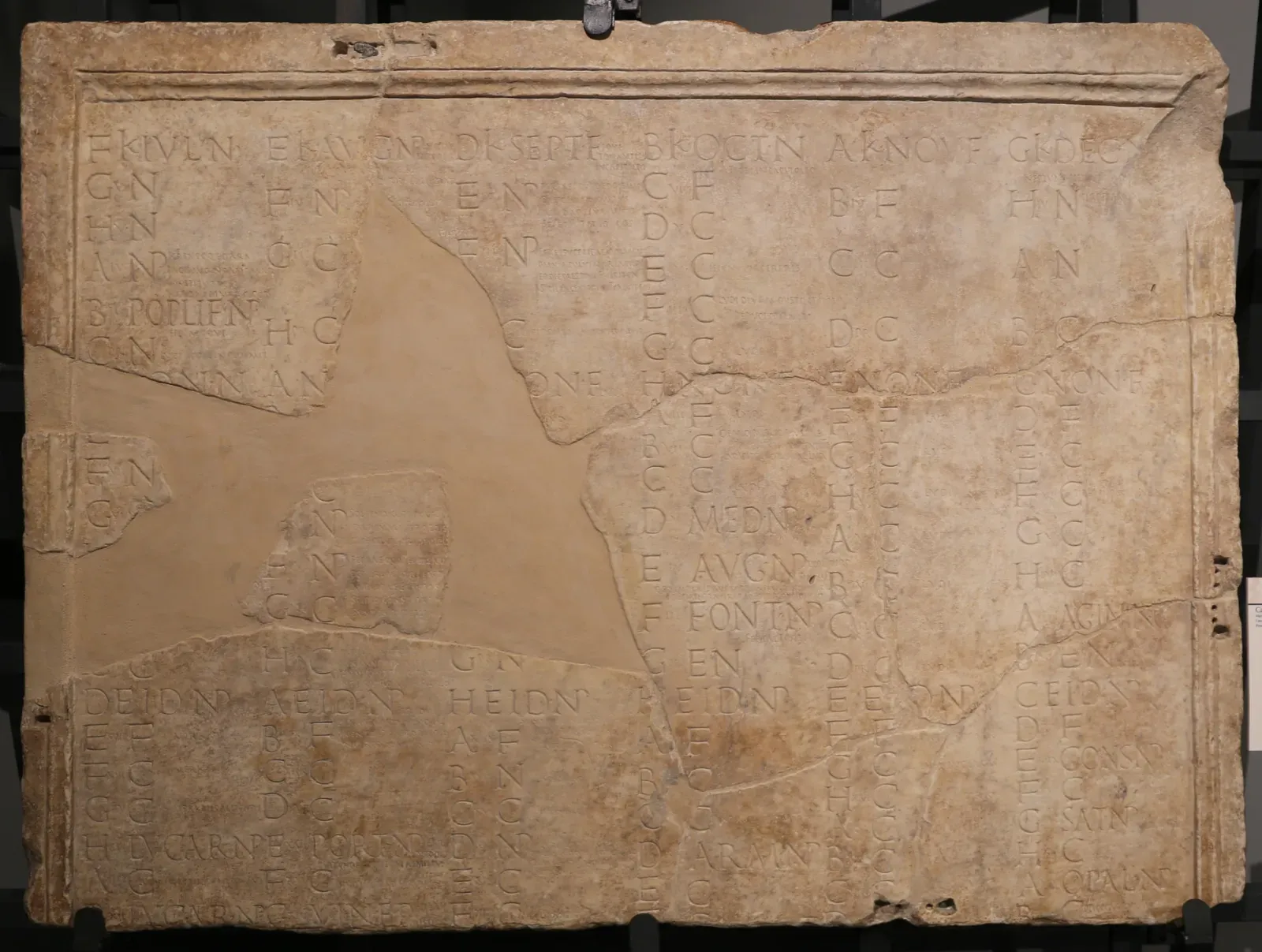 lastra de mármol del calendario de amiterno, de julio a diciembre: columnas de letras y abreviaturas grabadas, con una gran laguna rellenada con yeso liso