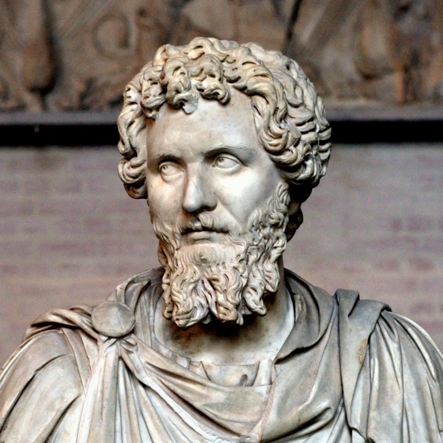 römische marmorbüste des kaisers septimius severus mit gelocktem bart und hartem blick